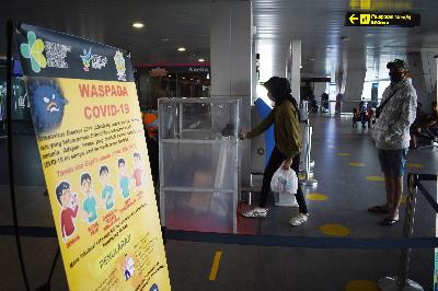 Penumpang memasukan tas ke bilik disinfektan di Bandara Internasional Husein Sastranegara, Bandung, Jawa Barat, 8 September 2020.  TEMPO/Prima Mulia