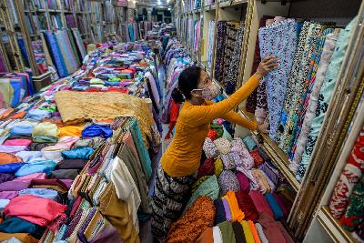 Pekerja menata kain bahan di Pasar Baru, Jakarta, 26 Oktober 2020. Tempo/Tony Hartawan