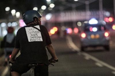 Pesepeda melintas saat malam hari di Jalan Jenderal Sudirman, Jakarta, 30 Oktober 2020. TEMPO/Hilman Fathurrahman W