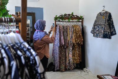 Pedagang butik baju batik dan tenun mengambil gambar baju yang akan di jual secara daring di Cipadu, Kota Tangerang, Banten, 21 Oktober 2020. Tempo/Tony Hartawan