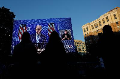 Wajah Joe Biden disaksikan warga Washington, Amerika Serikat melalui layar raksasa, 4 November 2020. REUTERS/Carlos Barria