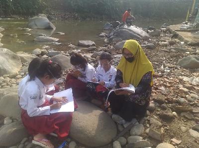 Siswa sekolah dasar sedang mengikuti pembelajaran jarak jauh di bantaran Sungai Ciliwung, Bogor, Jawa Barat, 10 November 2020. Tempo/MA. Murthado