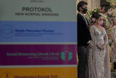 Pasangan pengantin mengenakan masker dalam simulasi pernikahan di era normal baru di Jakarta, 9 Juli 2020. Tempo/Tony Hartawan
