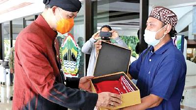 Gubernur Jawa Tengah Ganjar Pranowo (kiri) menerima kado dari mantan narapidana kasus terorisme Sri Puji Mulyo Siswanto, Rabu, 28 Oktober 2020. Humas Pemprov Jateng