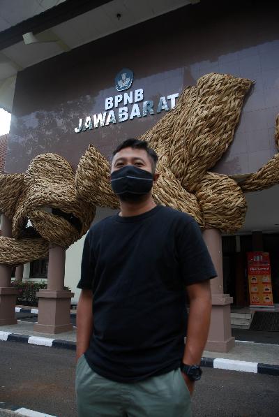 Seniman, Joko Avianto dengan latar instalasi raksasa karyanya berjudul Lawon Balebat di gedung Balai Pelestarian Nilai Budaya Jawa Barat, Bandung, 19 November 2020.  TEMPO/Prima Mulia