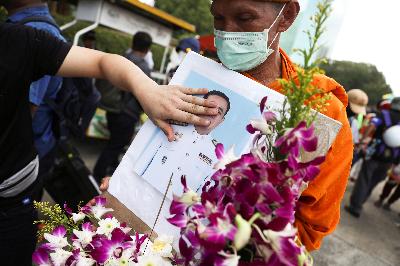 Seorang biksu memegang foto Perdana Menteri Thailand Prayuth Chan-ocha menuntut Raja Thailand Maha Vajiralongkorn menyerahkan kembali aset kerajaan kepada rakyat dan reformasi monarki, di Bangkok, Thailand, 25 November 2020. REUTERS/Athit Perawongmetha