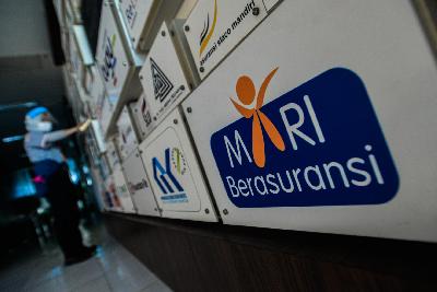 Petugas  membersihkan  logo-logo perusahaan asuransi di Kantor Asosiasi Asuransi Umum Indonesia (AAUI), Jakarta, 25 September 2020. Tempo/Tony Hartawan