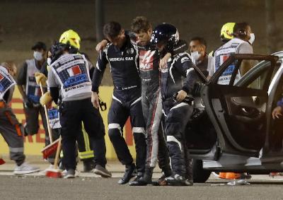 Romain Grosjean (tengah) menuju mobil ambulan akibat mengalami kecelakaan pada Bahrain Grand Prix di Bahrain International Circuit, Sakhir, Bahrain, 29 November 29 2020. REUTERS/Hamad I Mohammed