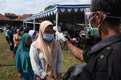 Petugas mengukur suhu tubuh saat simulasi Pilkada di Desa Mekarsari, Kecamatan Baleendah, Kabupaten Bandung, Jawa Barat, 21 November 2020. TEMPO/Prima Mulia
