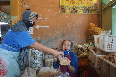 Buruh gendong perempuan membagikan bantuan makanan dari Dapur Umum Buruh Gendong Perempuan di Pasar Beringharjo, Yogyakarta, 2 Desember 2020. TEMPO/Shinta Maharani