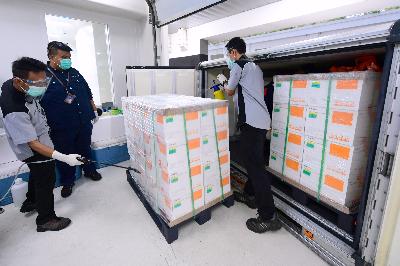 Petugas menyemprotkan cairan desinfektan kontainer berisi vaksin COVID-19 saat tiba di Kantor Pusat Bio Farma, Bandung, Jawa Barat, 7 Desember 2020. ANTARA/HO/Setpres-Muchlis Jr