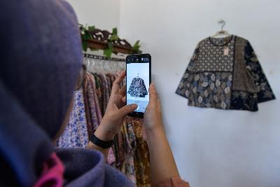 Pedagang tenun dan batik Dewi Sabi  mengambil gambar baju yang akan di jual secara daring di Cipadu, Kota Tangerang, Banten 20 Oktober 2020. Tempo/Tony Hartawan