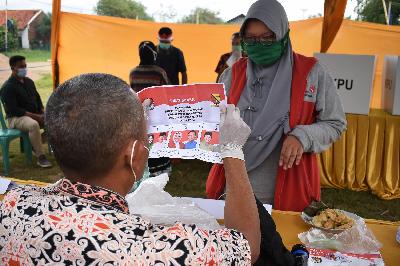 Petugas KPPS memeriksa surat suara sebelum pencoblosan di tempat pemungutan suara pemilihan kepala daerah di  Kabupaten Bandung, Jawa Barat, 9 Desember 2020. TEMPO/Prima Mulia