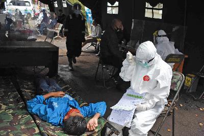 Dokter memeriksa pasien bergejala demam dan hilang indera penciuman di tenda infeksius Puskesmas Tamblong, Bandung, Jawa Barat,  7 Desember 2020. TEMPO/Prima Mulia