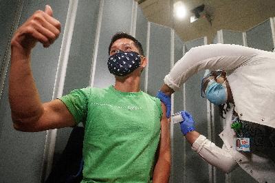 Dokter Tommy Wong menerima vaksin Covid-19 dari  Pfizer-BioNTech di rumah sakit Mt. Sinai, New York, Amerika Serikat, 15 Desember 2020. REUTERS/Carlo Allegri