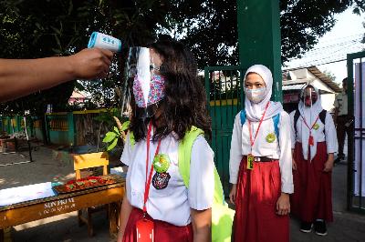 Siswa menjalani pemeriksaan suhu tubuh sebelum mengikuti pembelajaran tatap muka di SDN 06 Pekayon Jaya, Bekasi, Jawa Barat, 3 Agustus 2020. TEMPO / Hilman Fathurrahman W