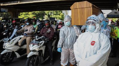 Petugas mengenakan baju APD membawa peti mati saat sosialisasi bahaya COVID-19 di Traffic Light Jalan RS. Fatmawati Raya, Jakarta Selatan, 26 Agustus 2020. TEMPO/M Taufan Rengganis