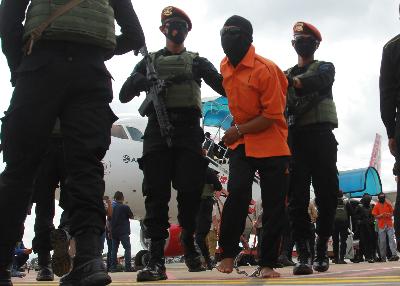 Petugas Detasemen Khusus (Densus) 88 membawa 1 dari 23 orang terduga teroris jaringan Jamaah Islamiyah (JI) yang ditangkap di Lampung tiba di Bandara Soekarno Hatta, Tangerang, Banten, 16 Desember 2020. ANTARA/Muhammad Iqbal