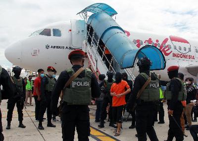 Petugas Detasemen Khusus (Densus) 88 membawa 1 dari 23 orang terduga teroris jaringan Jamaah Islamiyah (JI) yang ditangkap di Lampung tiba di Bandara Soekarno Hatta, Tangerang, Banten, 16 Desember 2020. ANTARA/Muhammad Iqbal