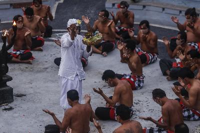 Seorang tokoh agama Hindu memercikan air suci kepada seniman sebelum menampilkan Tari Kecak di panggung terbuka Pura Uluwatu, Kabupaten Badung, Bali, 31 Oktober 2020.  Johannes P. Christo
