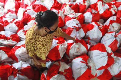 Warga memeriksa paket bantuan sosial (bansos) berupa  kebutuhan pokok di kawasan Pasar Minggu, Jakarta Selatan, 28 April 2020.  TEMPO/Nita Dian