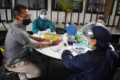 Dokter memeriksa warga sebelum divaksin saat simulasi penyuntikan vaksin Covid-19 Sinovac di Pusat kesehatan Masyarakat Balai Kota Bandung, Jawa Barat, 23 Desember 2020.  TEMPO/Prima Mulia