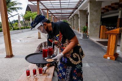 Pegawai hotel mengenakan pelindung diri saat menghidangkan minuman di Hotel Inaya Putri Bali, Nusa Dua, Bali, 5 Juni 2020. Johannes P. Christo