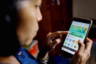 Pengguna telepon pintar melihat aplikasi Akulaku di Jakarta, 6 Januari 2020. Tempo/Tony Hartawan