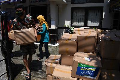 Warga membawa paket bantuan sosial sembako di Kelurahan Kebon Pisang, Bandung, Jawa Barat, 16 Mei 2020. TEMPO/Prima mulia