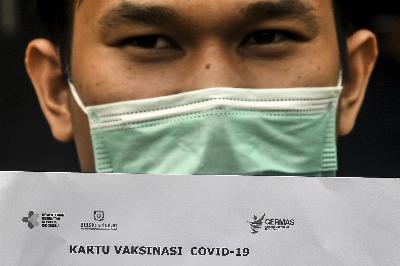 Seorang pasien menunjukkan kartu vaksinasi COVID-19 saat simulasi pemberian vaksin COVID-19 Sinovac di Puskesmas Kelurahan Cilincing I, Jakarta, 12 Januari 2021. ANTARA/Muhammad Adimaja