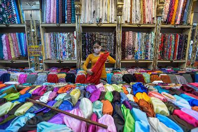 Pekerja tengah menata kain bahan di Pasar Baru, Jakarta, 26 Oktober 2020. Tempo/Tony Hartawan