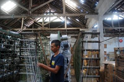 Pekerja mengatur alur benang di sebuah pabrik kain skala kecil menengah di Desa Rancajigang, Kecamatan Majalaya, Kabupaten Bandung, Jawa Barat, 9 Novembe 2021. TEMPO/Prima Mulia