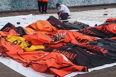 Tim SAR gabungan memindahkan kantong jenazah di Posko Pencarian Pesawat Sriwijaya Air SJ-182, Dermaga JICT 2, Tanjung Priok, Jakarta Utara, 14 Januari 2021.  TEMPO/Hilman Fathurrahman W
