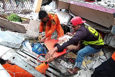 Petugas mengevakuasi korban di rumah sakit Mitra Manakarra yang runtuh akibat gempa bumi di Mamuju, Sulawesi Barat, 15 Januari 2021. ANTARA/Akbar Tado