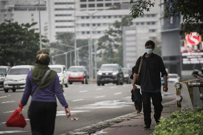 Pejalan kaki menggunakan masker saat Pemberlakukan Pembatasan Kegiatan Masyarakat di kawasan Jalan Jenderal Sudirman, Jakarta, 21 Januari 2021. TEMPO/M Taufan Rengganis