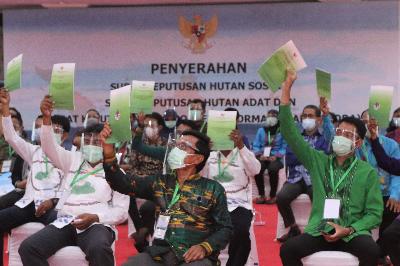 Perwakilan warga mengangkat SK Kehutanan Sosial saat Presiden Joko Widodo menyerahkannya secara virtual di Kendari, Sulawesi Tenggara, 7 Januari 2021. ANTARA/Jojon