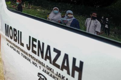 Keluarga melihat prosesi pemakaman keluarganya yang menjadi korban wabah Covid-19 di TPU Bambu Apus, Jakarta Timur, 26 Januari 2021. TEMPO / Hilman Fathurrahman W