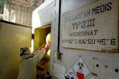 Petugas medis memasukan limbah infeksius ke insinerator di sebuah rumah sakit di Jakarta pusat, 1 Juli 2020. TEMPO/Muhammad Hidayat