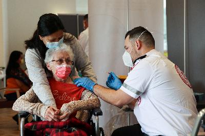 Seorang wanita usia lanjut menerima suntikan vaksinasi corona (Covid-19) di Israel, 19 Januari 2021. REUTERS/Ronen Zvulun