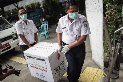 Petugas membawa kotak berisi Vaksin Covid-19 saat tiba di Puskesmas Kecamatan Cilincing, Jakarta Utara, 13 Januari 2021.  TEMPO/M Taufan Rengganis