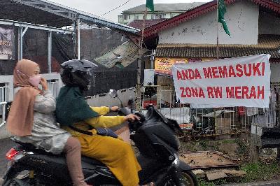 Spanduk bertuliskan Anda Memasuki Zona RW Merah terpasang di kawasan Srengseng Sawah, Jakarta, 22 Januari 2021.  TEMPO/Subekti.