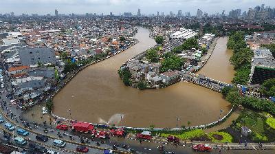 Air Kali Ciliwung yang mulai tumpah ke jalanan di Kampung Pulo, Jakarta, 8 Februari 2021. TEMPO/Subekti.