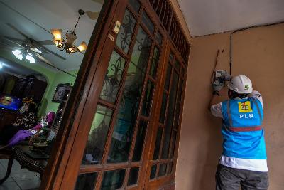 Petugas PLN melakukan penambahan daya di kWh Meter pelanggan, Cipete Utara, Kebayoran Baru, Jakarta, 6 Agustus 2020. Tempo/Tony Hartawan