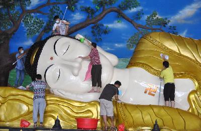 Sejumlah pekerja vihara membersihkan Patung Budha Tidur saat ritual pencucian di Vihara Buddha Dharma dan 8 Posat, Tajurhalang, Bogor, Jawa Barat, 7 Februari 2021.  ANTARA/Arif Firmansyah
