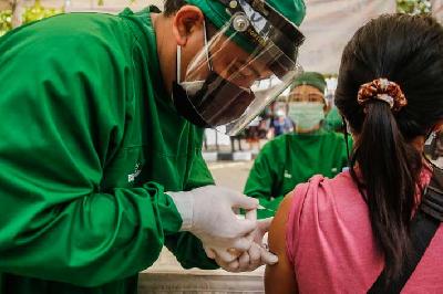 Vaksinator menyuntikan vaksin COVID-19 Sinovac pada seorang tenaga kesehatan di Denpasar, Bali, 4 Februari 2021. Johannes P. Christo