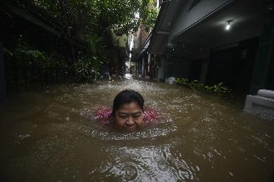 Seorang warga Kampung Baru I berusaha menyelamatkan diri dari bencana banjir di kawasan Halim Perdanakusuma, Jakarta Timur, 20 Februari 2021. TEMPO/Imam Sukamto