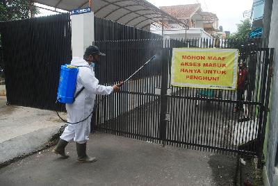 Petugas kelurahan melakukan penyemprotan di gerbang masuk permukiman saat kampanye disiplin 3 M dan PPKM skala mikro di kawasan Antapani, Bandung, Jawa Barat, 10 Februari 2021. TEMPO/Prima Mulia