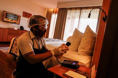 Petugas hotel membersihkan gagang telepon dengan cairan disinfektant di Nusa Dua, Bali, 5 Juni 2020. FOTO: Johannes P. Christo