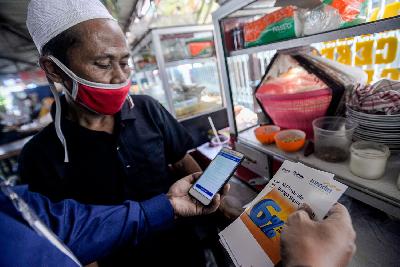 Tenaga pemasar mikro Bank Mandiri  menjelaskan aplikasi Mandiri Pintar untuk memproses kredit mikro produktif kepada pedagang di Pasar Majestik, Jakarta, 29 Juni 2020. TEMPO/Tony Hartawan