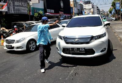 Petugas parkir saat mengarahkan kendaraan di Jakarta,  21 Agustus 2019.  TEMPO / Hilman Fathurrahman W